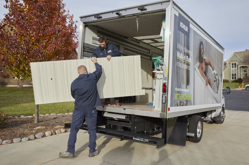 Two men unloading suplies from their truck